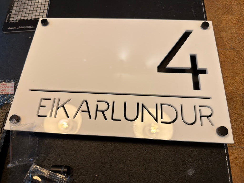Hvítt akrýl húsnúmer Eikarlundur 4 með fjarlægðarboltum