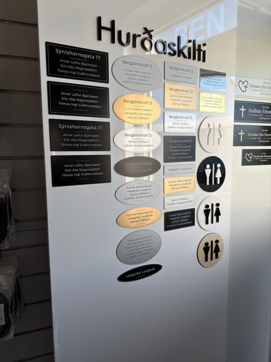 Sýningarveggur með hurðaskiltum í verslun Skilti og Merkingar