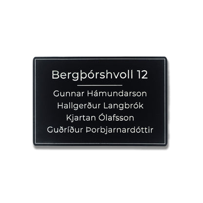 Svart hurðaskilti úr akrýl með hvítum stöfum og heimilisfangi. Nafnaskilti á hurð fyrir heimili.