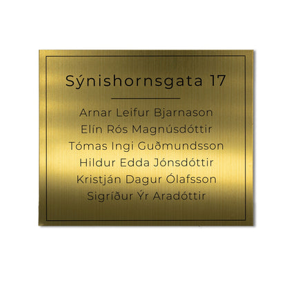 Stórt skilti á hurð úr messing með heimilisfangi.