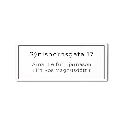 Hvítt skilti á póstkassa með heimilisfangi.