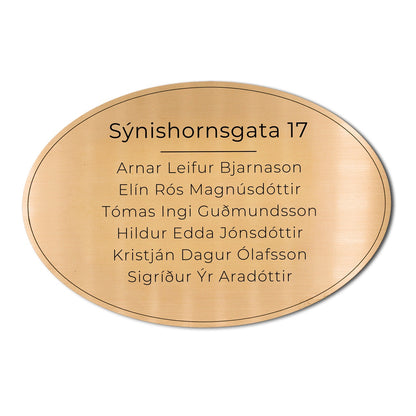 Stórt sporöskjulaga skilti á hurð með heimilisfangi.