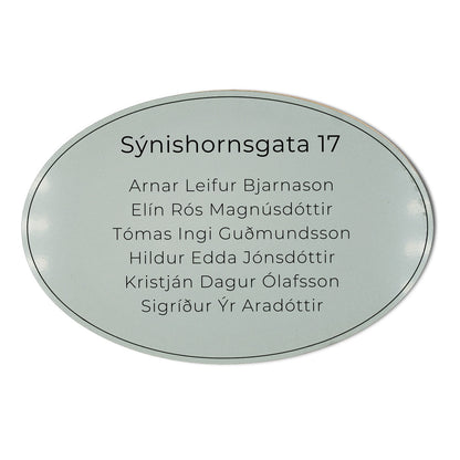 Stórt sporöskjulaga skilti á hurð með heimilisfangi.