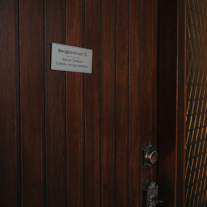 Silfur nafnaskilti með götuheiti. Skýr svartan texta á silfur bakgrunn.