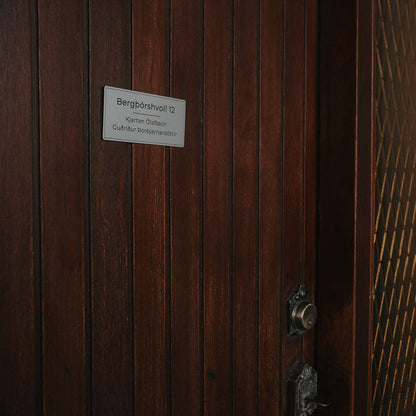 Silfur nafnaskilti með götuheiti. Skýr svartan texta á silfur bakgrunn.