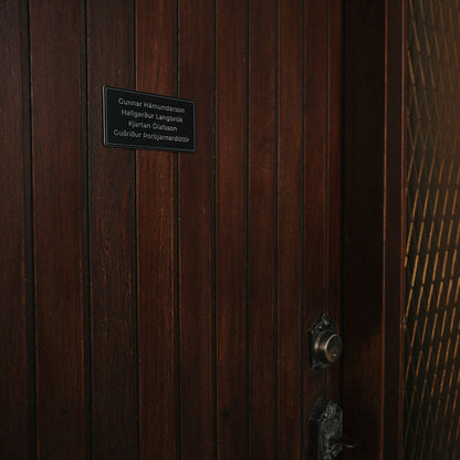 Svart nafnaskilti á hurð í miðstærð. Vinsælasta stærðin fyrir fjölskyldur.